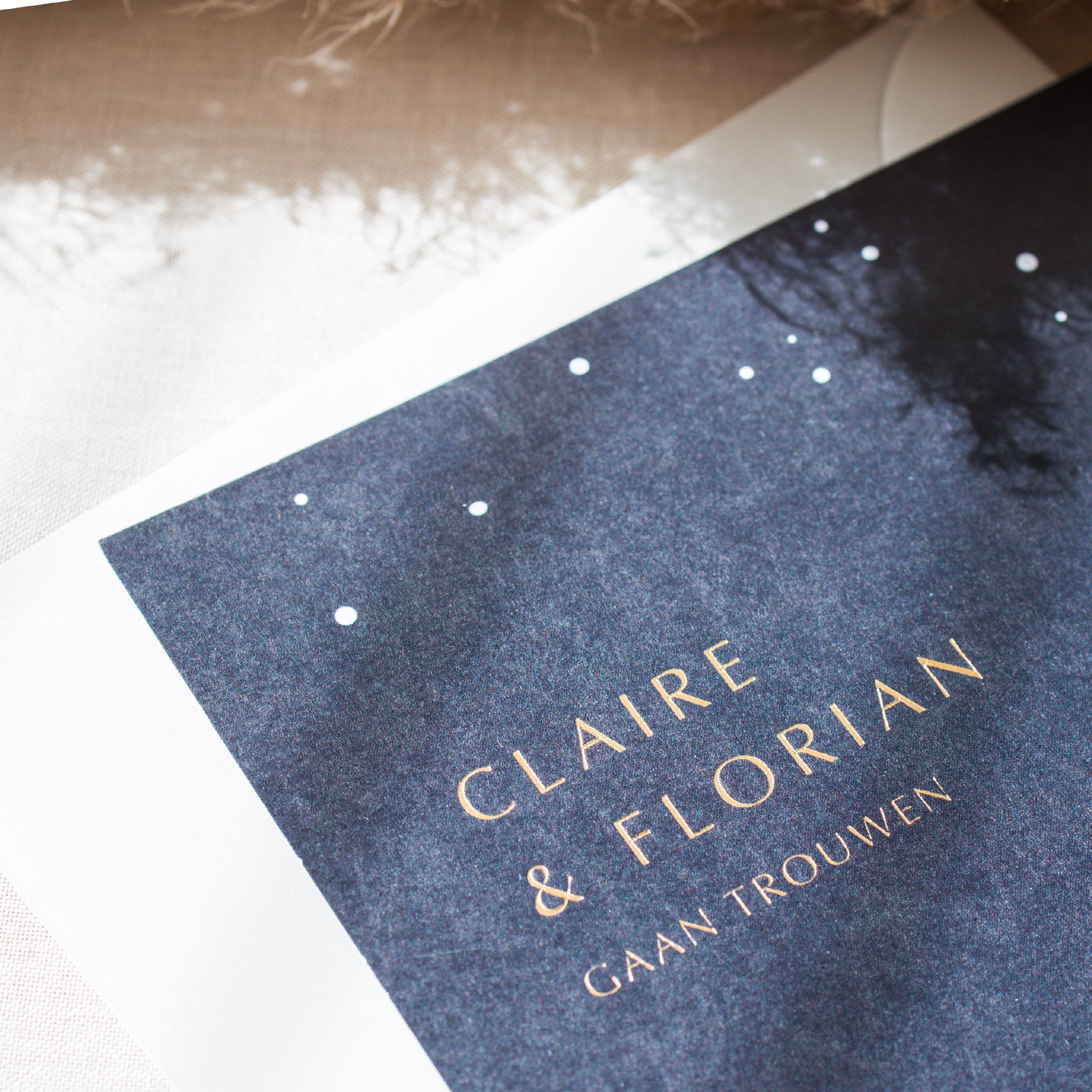 Huwelijksuitnodiging gedrukt met full colour afgewerkt met letterpress foliedruk in de kleur mat goud